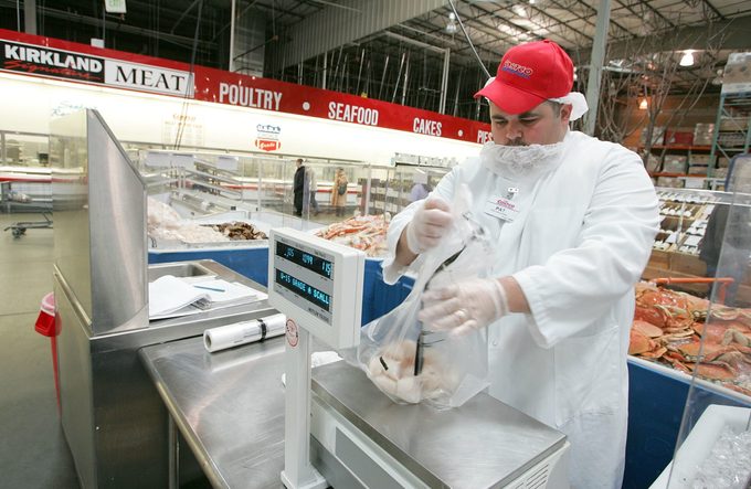 Costco employee weighing seafood