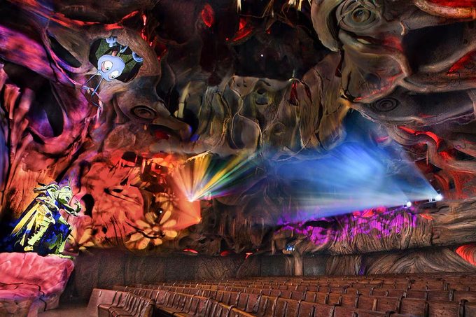 Inside theater of "it's tough to be a bug" attraction with multicolored lights and bug animatronics
