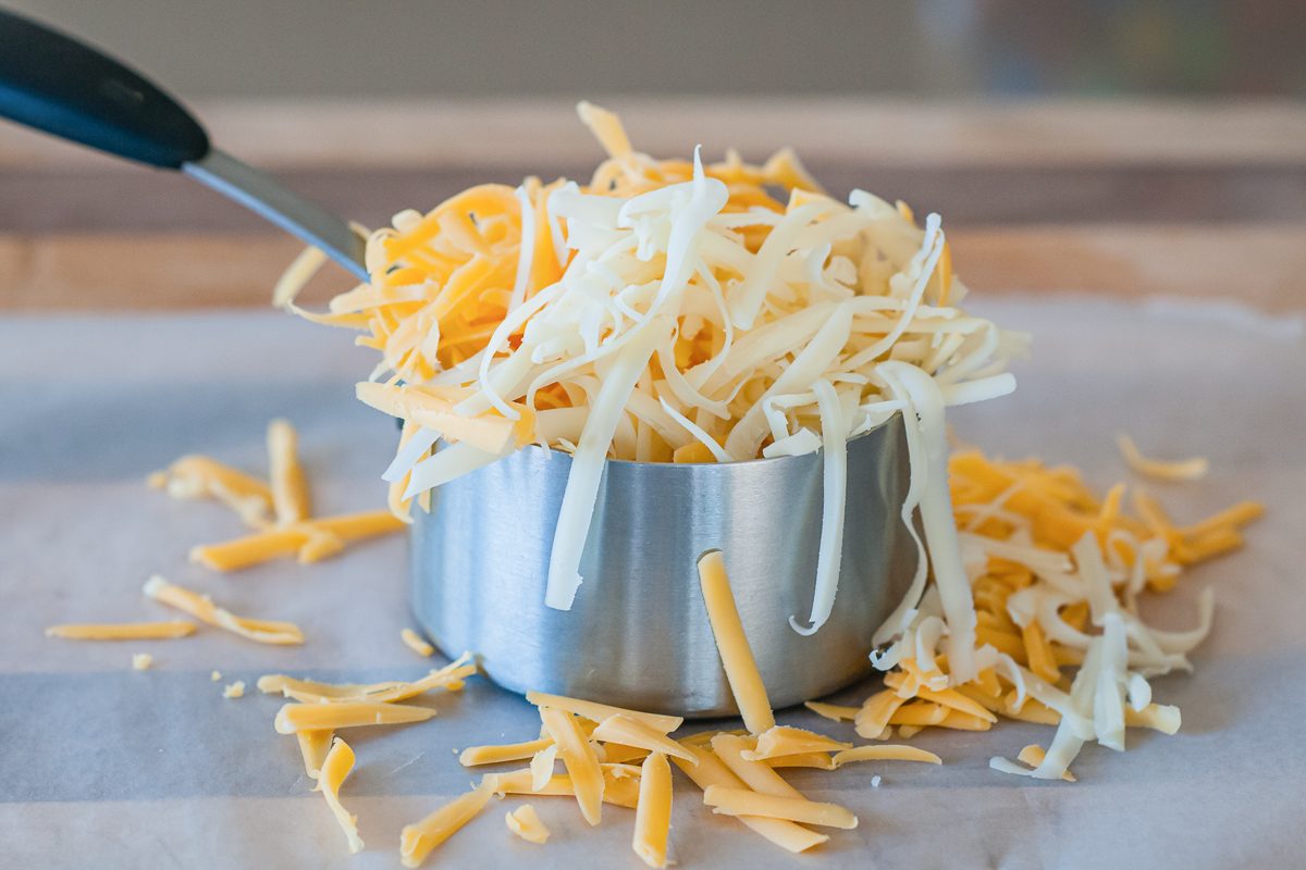 cheese overflowing out of measuring cup
