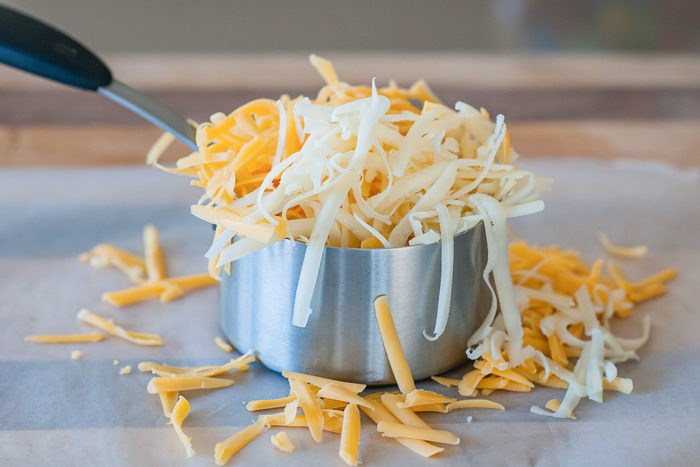 cheese overflowing out of measuring cup
