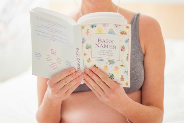 woman reading book of baby names
