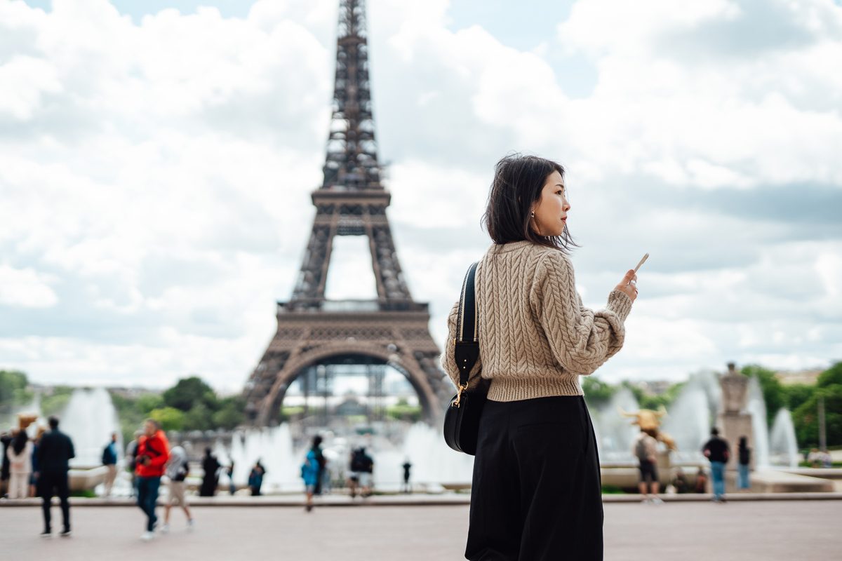 asian woman in front of the Eiffel Tower