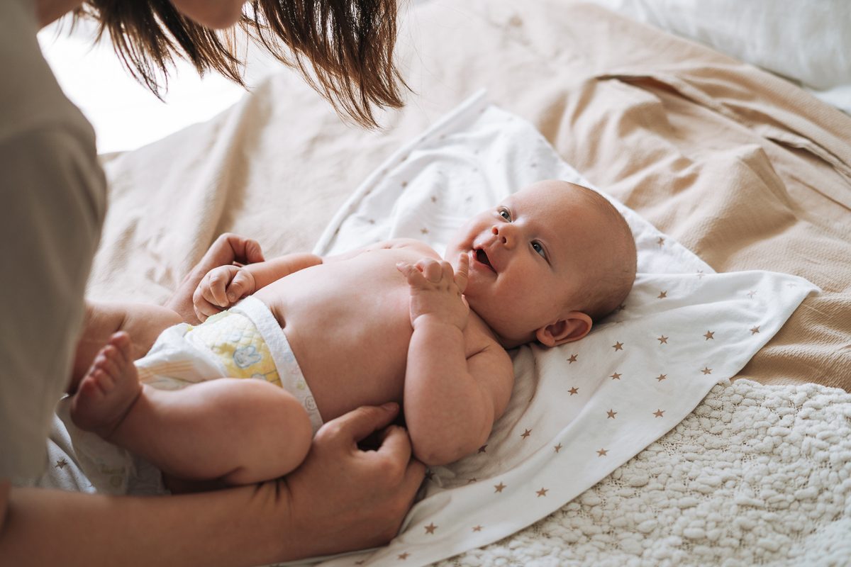 young mother with baby boy lying on the bed