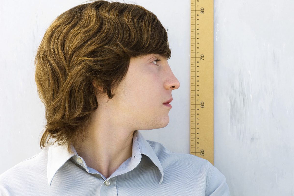 man standing next to yardstick