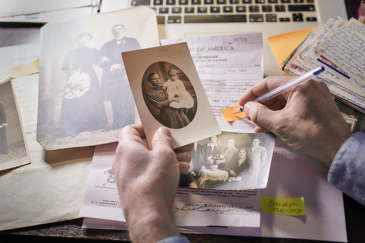 Man doing research on family members looking at old photographs