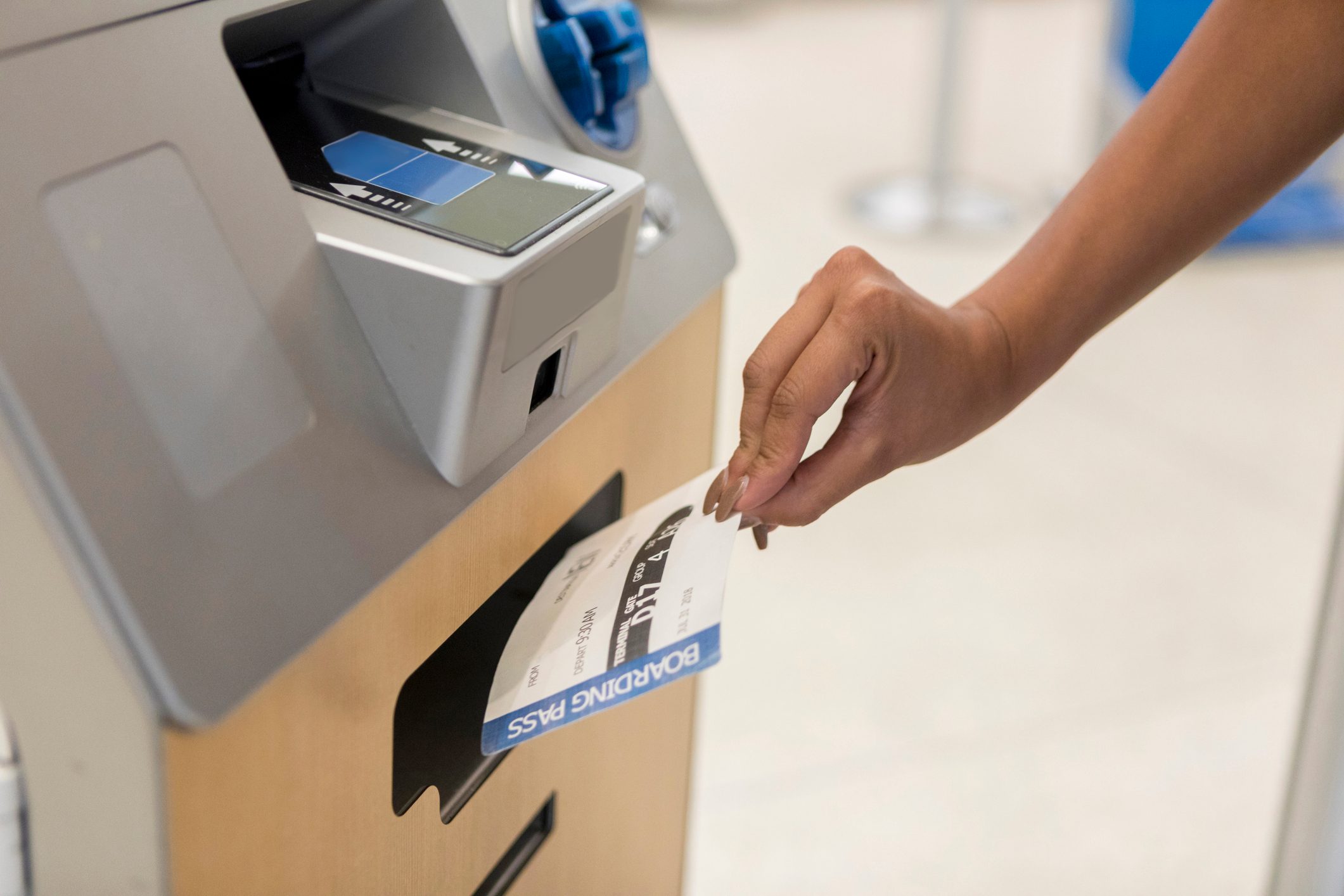 Woman receives boarding pass at kiosk
