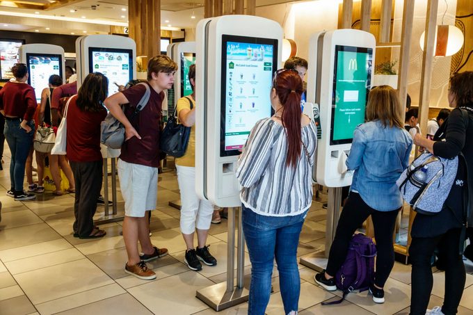 Customers order from touchscreen kiosks at McDonald's restaurant