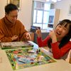 Father and daughter playing Monopoly at kitchen table