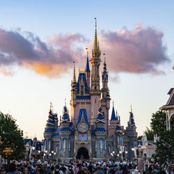 Cinderella's Castle at the Walt Disney World Magic Kingdom at sunset with purple and orange clouds