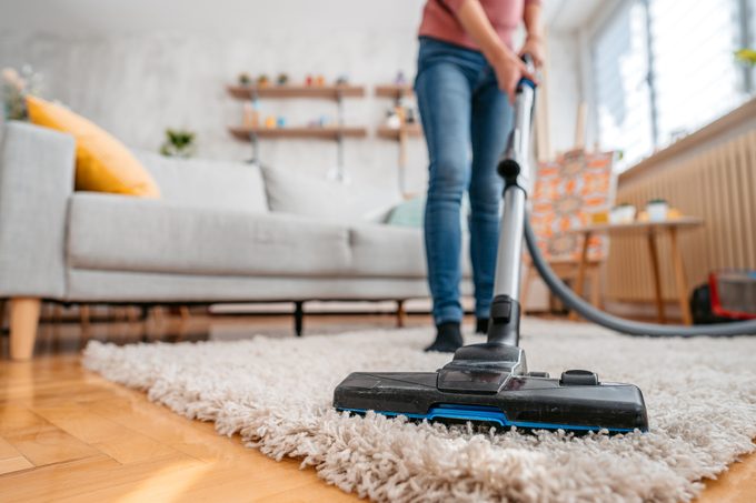 Young Woman Vacuuming Her Apartment