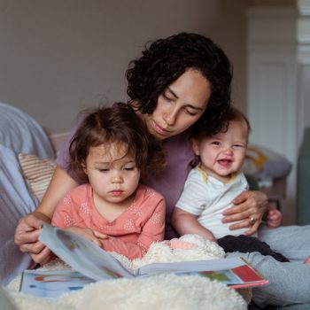 Mom enjoying relaxing morning at home with two sleepy and happy kids