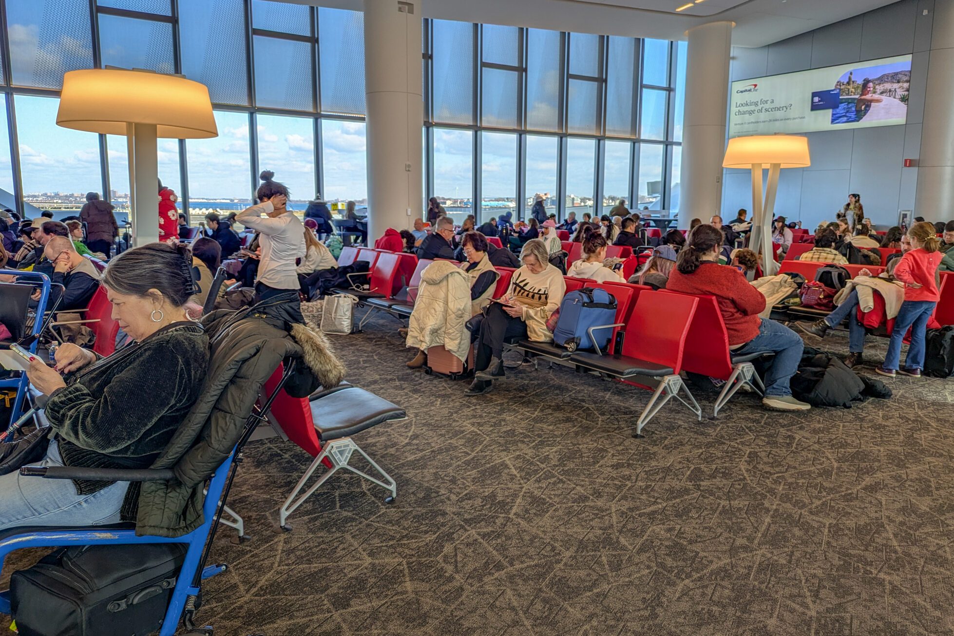 People waiting in the waiting room to take their plane at LaGuardia Airport in New York