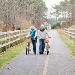 Mature couple with bicycles on a country road in winter