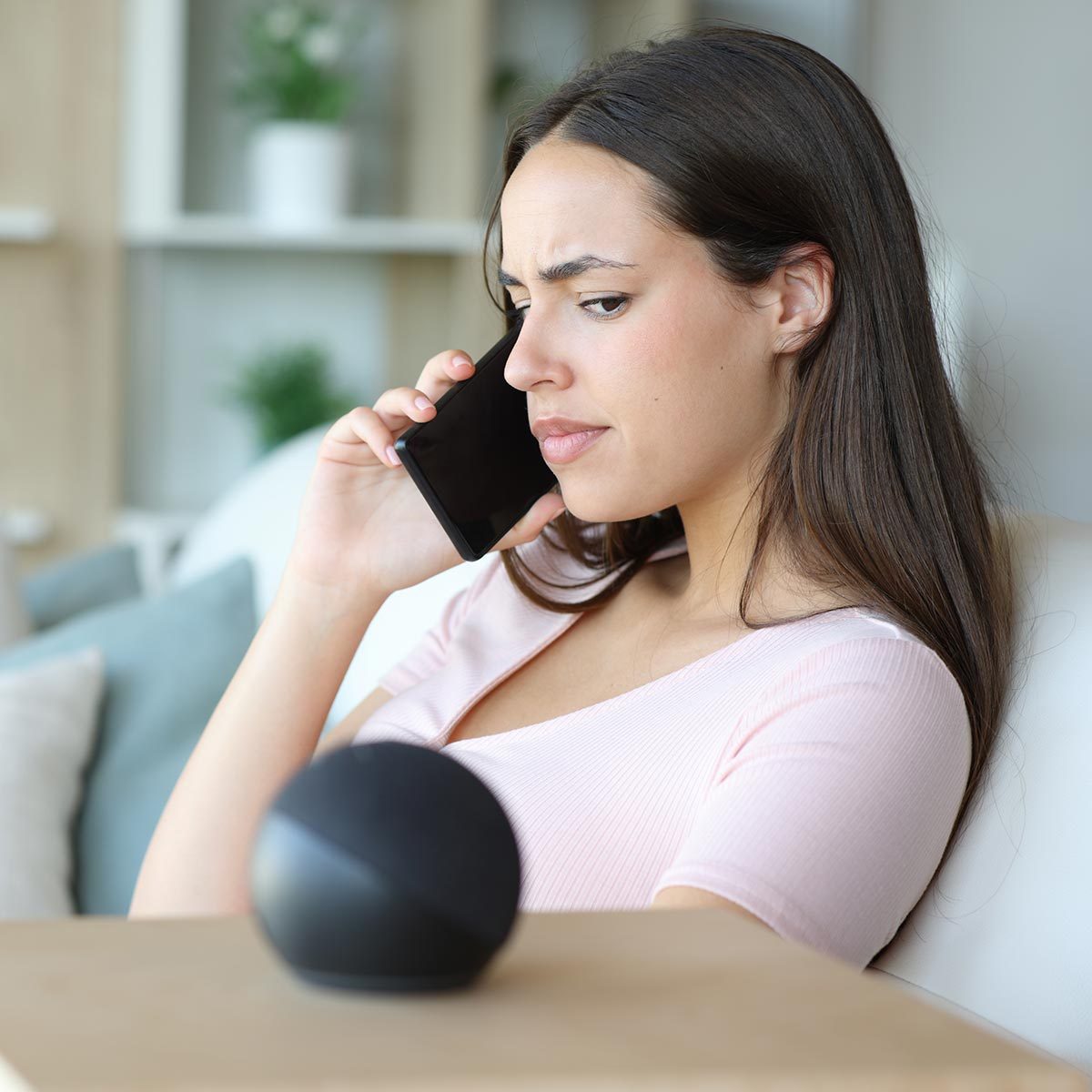 A women looking at the smart speaker suspiciously