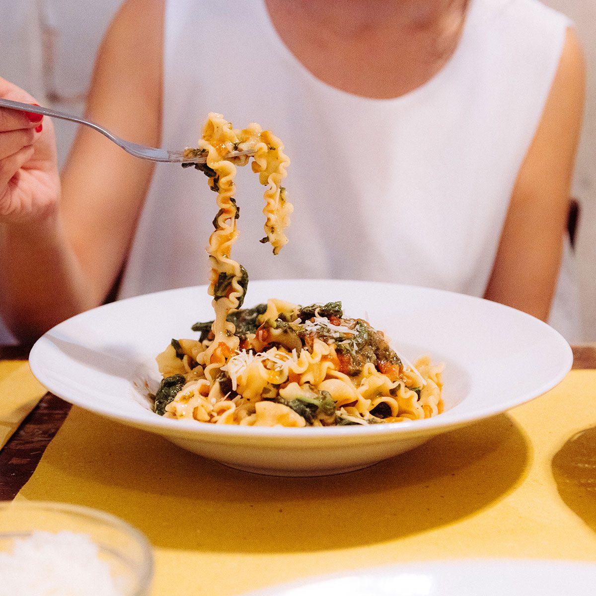 A girl eating pasta in a restaurent