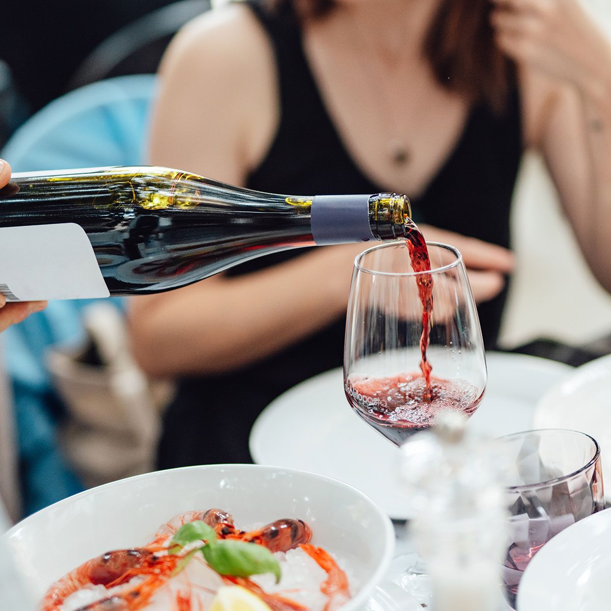wine is being poured in a glass