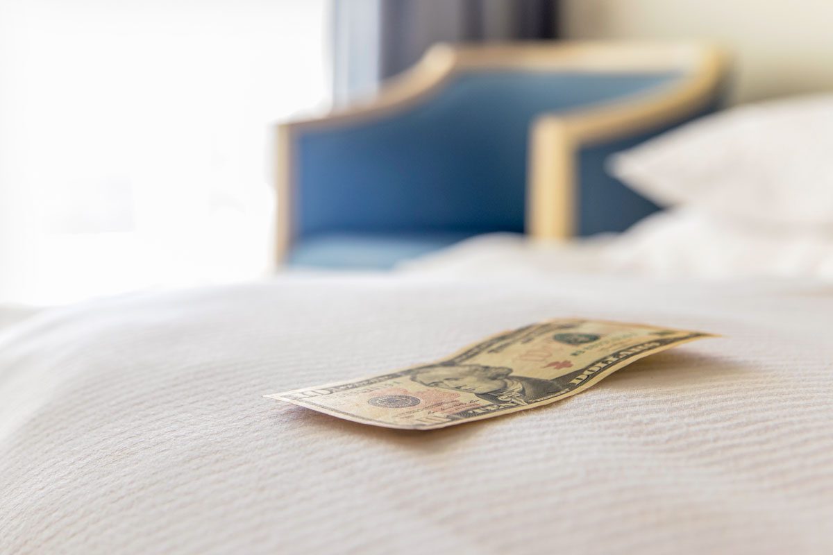 Traditional Tips Is Laying On The Corner Of Bed In Hotel Room