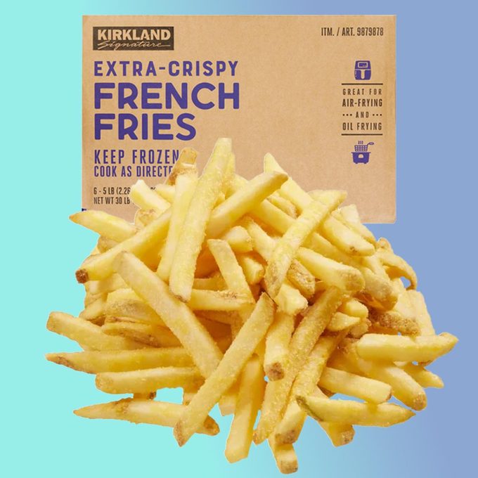 Kirkland extra-crispy french fries box with cooked fries on a blue background