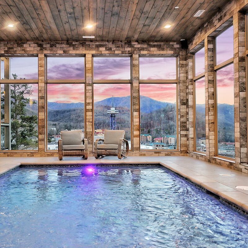 Indoor pool with a sunset view of mountains beyond