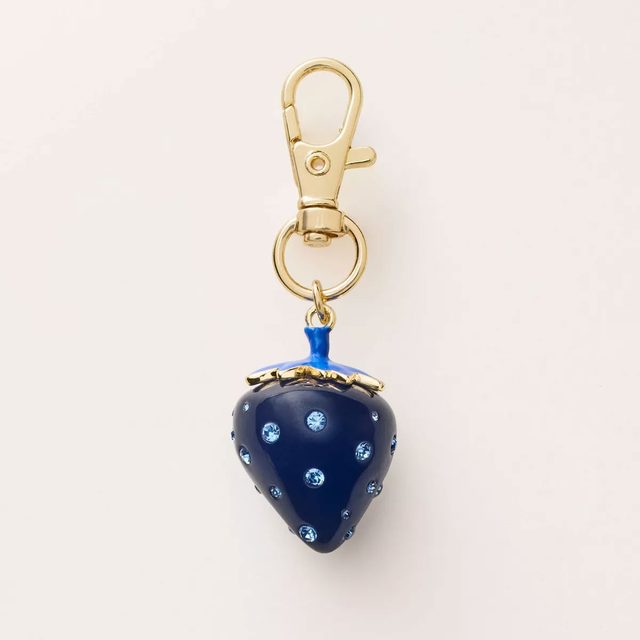 Blue strawberry keychain on a tan background
